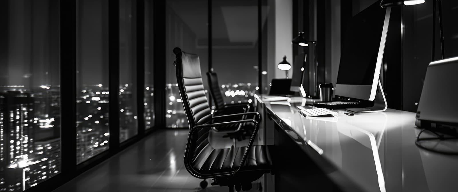 A dark office at night with the city beyond