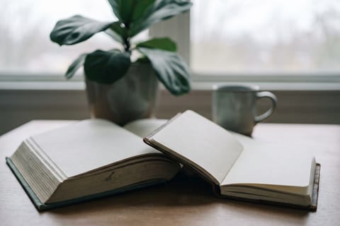 A large open book beside a small pocket notebook